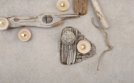 Photo for Sea driftwood pieces and tea light candles on stone background. Pieces of sea drift wood, top view. Bleached dry aged drift wood. - Royalty Free Image
