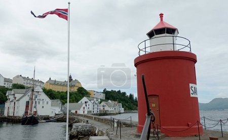 Molja Leuchtturm im alten Hafen von Alesund, Norwegen. Leuchtturm Molja vor dem Lagergebäude von Olaf Holf, Fischereimuseum (Fischereiindustrie)).