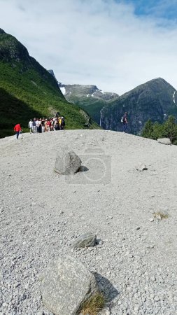 Foto de Olden, Noruega - 8 de julio de 2023: Turistas visitan el Glaciar Briksdalsbreen. Turistas en la cima del glaciar, senderismo a través de la hermosa montaña salvaje. - Imagen libre de derechos