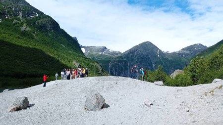 Téléchargez les photos : Olden, Norvège - 8 juillet 2023 : Des touristes visitent le glacier Briksdalsbreen. Touristes sur le sommet du glacier, randonnée à travers la magnifique nature sauvage de montagne. - en image libre de droit