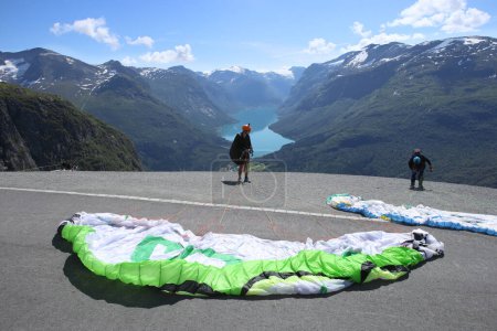 Foto de Stryn, Noruega - 8 de julio de 2023: Los parapentes se están preparando para volar en la cima del Skylift de León en Noruega. Parapente sobre Loen y la parte interior de nordfjord, Noruega. - Imagen libre de derechos