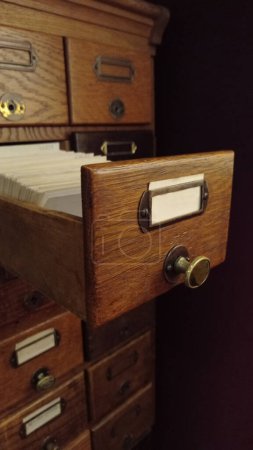 Meuble vintage avec cartes de bibliothèque ou catalogue de fichiers. Ancien catalogue de cartes en bois avec tiroir ouvert.