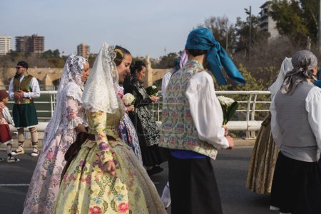 Téléchargez les photos : Valence, Espagne - 17 mars 2024 : Des gens en costumes traditionnels vont offrir des fleurs à Notre-Dame des Abandonnés à Valence, Espagne - en image libre de droit