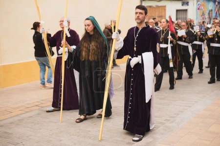 Téléchargez les photos : Valence, Espagne - 24 mars 2024 : Des personnes en costumes religieux participent à la procession du dimanche des Rameaux à Valence, Espagne - en image libre de droit