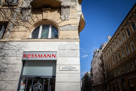 Téléchargez les photos : BUDAPEST, HONGRIE - 26 FÉVRIER 2022 : Logo Rossmann devant leur magasin principal à Budapest. Rossmann est une chaîne allemande de pharmacies, de dogeries et de magasins de cosmétiques répartis en Europe - en image libre de droit