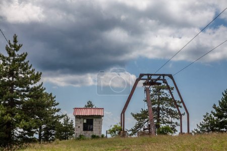 Téléchargez les photos : Neglected decaying stopped ski lifts, not working in summer, in Divcibare ski resort, by slopes, in the middle of balkans mountain in Serbia. Divcibare is one of the main ski tourism destinations of Serbia - en image libre de droit