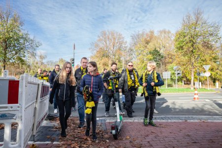 Photo for DORTMUND, GERMANY - NOVEMBER 5, 2022: Selective blur on BVB Borussia Dortmund supporters on their way to the stadium including children getting prepared for a football match of Borussia. - Royalty Free Image
