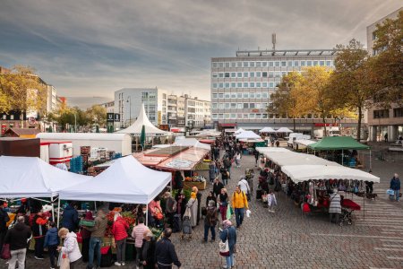 Photo for MULHEIM, GERMANY - NOVEMBER 12, 2022: Panorama of the Wiener Platz square in Mulheim with the local farmers market occurring, with a crowd of people, clients, germany people, buying groceries. - Royalty Free Image