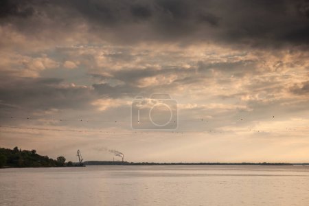 Téléchargez les photos : Panorama du Danube (Dunav) au début de la Porte de fer (djerdap) à Banatska palaka, au crépuscule avec les fumées et les fumées d'une usine, une centrale électrique, polluant l'atmosphère en arrière-plan, en Serbie. - en image libre de droit