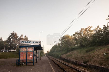 Photo for BARAJEVO, SERBIA - MAY 15, 2022: Railway tracks, rails and platforms in a suburban train station in Barajevo in Serbia, electrified, with power overhead line, on a single track main railroad line. - Royalty Free Image