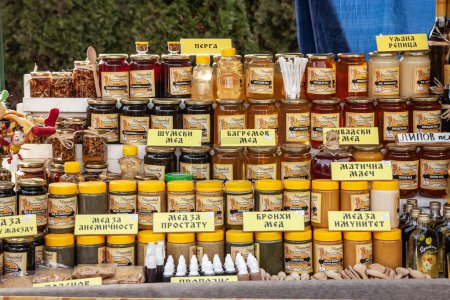 Photo for KACAREVO, SERBIA - FEBRUARY 18, 2023: Jars of Honey, Serbian honey (srpski med) on display in a rural market. Honey is a traditional production of the agricultural serbian countryside. - Royalty Free Image