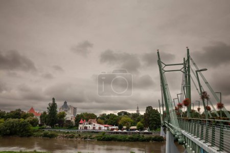 Téléchargez les photos : ARAD, ROUMANIE - 17 SEPTEMBRE 2022 : Panorama de la rivière Mures et de la rive de la rivière à Arad, Roumanie, depuis le pont piéton podul pendant un après-midi pluvieux. Arad est une grande ville roumaine dans le nord du pays. - en image libre de droit