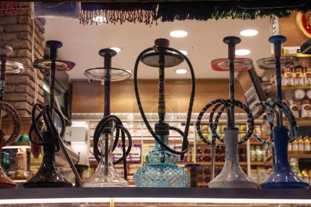 Photo for Selective blur on hookah, or narghile, for sale with their waterpipes in a bazaar of Istanbul Turkey. it's a typical middle east device used to smoke tobacco. - Royalty Free Image