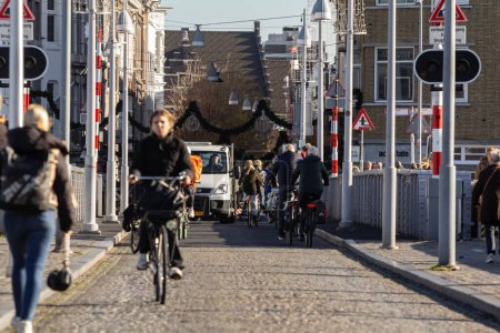 Photo for MAASTRICHT, NETHERLANDS - NOVEMBER 10, 2022: People biking on Sint Servaasbrug bridge in Maastricht city center. Netherlands are known for people using bicycle as transportation. - Royalty Free Image