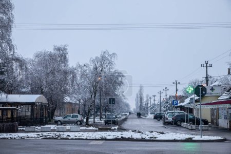 Téléchargez les photos : BAVANISTE, SERBIE - 9 JANVIER 2022 Flou sélectif sur la rue principale cente de la ville dans le village de Bavaniste, Vojvodine, Banat,, à la campagne, couvert de neige, pendant l'hiver froid froid après-midi de gel. - en image libre de droit