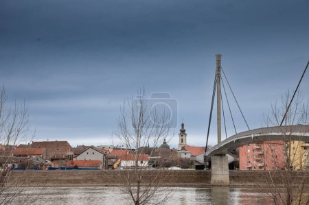 Photo for Panorama of Sremska Mitrovica with Saint Irinej bridge (Most Svetog Irineja) during a cold grey winter afternoon. Sremska Mitrovica is one of the main cities of the northern Serbian Region of Srem. - Royalty Free Image