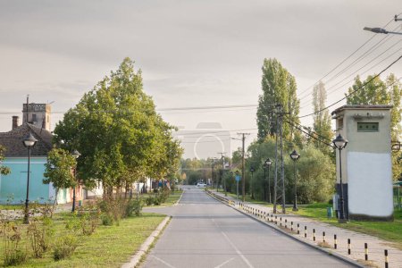 Typische Landstraße im Dorf Jabuka, einem serbischen Dorf in der Banat-Region Vojvodina, Serbien, am Nachmittag, mit menschenleeren Straßen.