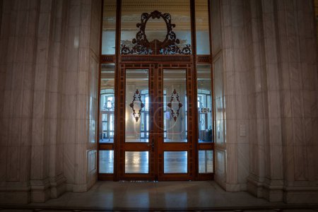 Foto de BUCHAREST, RUMANIA - 13 DE MARZO DE 2023: Desenfoque selectivo en las puertas de madera y vidrio y diseño opulento del interior del palacio del parlamento rumano en Bucarest, un símbolo del comunismo rumano. - Imagen libre de derechos