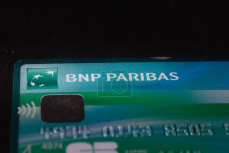 Téléchargez les photos : PARIS, FRANCE - 15 AVRIL 2023 : Flou sélectif sur un logo BNP Paribas sur une carte bleue. BNP Paribas est une banque française, l'une des plus importantes de France et d'Europe - en image libre de droit