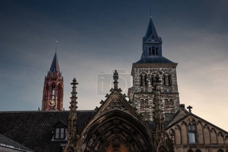 Foto de Sint Servaasbasiliek, o basílica de San Servacio, una iglesia católica romana en Maastricht, Países Bajos, en una puesta de sol soleada al atardecer. Es una icónica iglesia católica.. - Imagen libre de derechos