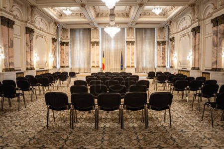 Foto de BUCHAREST, RUMANIA - 13 DE MARZO DE 2023: Desenfoque selectivo en sillas vacías en una sala de conferencias con un diseño opulento en el interior del palacio del parlamento rumano en Bucarest símbolo del comunismo rumano. - Imagen libre de derechos
