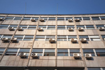 Photo for Air Conditioning Units, or AC, with their fans on a decaying facade of an old high rise business building of Belgrade, Serbia, Europe. They are used to cool down interiors, but consume a lot of electricity. - Royalty Free Image