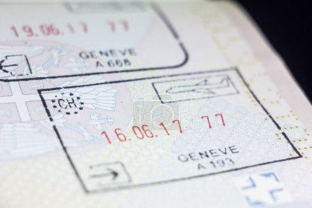 Selektive Unschärfe auf einem Schweizer Passstempel auf einem serbischen Pass, vom Grenzübergang des Genfer Flughafens namens Geneve Aeroport, unter Einhaltung der Bestimmungen des Schengen-Passstempels der Europäischen Union.