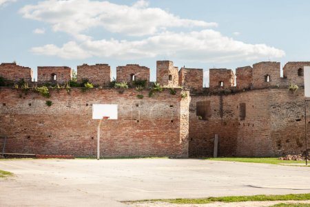 Foto de Antiguo, medio destruido, tablero de baloncesto podrido, en un patio de recreo deportivo en decadencia, de pie frente a una pared en ruinas en Ilok, Croacia. - Imagen libre de derechos