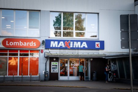 Téléchargez les photos : SIGULDA, LETTONIE - 23 AOÛT 2023 : Logo du supermarché Maxima sur leur magasin de Sigulda. Maxima Group est un groupe lituanien de vente au détail spécialisé dans les supermarchés et autres épiceries dans les États baltes. - en image libre de droit