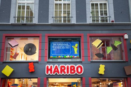 Foto de BONN, ALEMANIA - 7 DE NOVIEMBRE DE 2022: logotipo haribo en su tienda en Bonn. haribo es un productor alemán de confitería conocido por sus dulces, especialmente gomosos. - Imagen libre de derechos