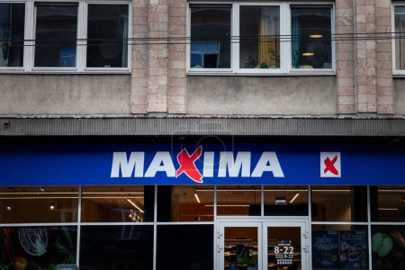 Téléchargez les photos : RIGA, LETTONIE - 23 AOÛT 2023 : Logo du supermarché Maxima sur leur magasin de Riga. Maxima Group est un groupe lituanien de vente au détail spécialisé dans les supermarchés et autres épiceries dans les États baltes. - en image libre de droit