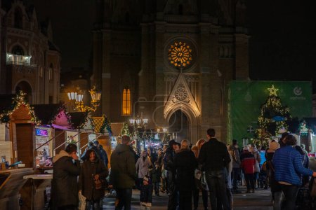 Téléchargez les photos : NOVI SAD, SERBIE - 4 DÉCEMBRE 2022 : Flou sélectif sur les Boutiques du marché de Noël de Novi Sad sur la place trg slobode devant la triste cathédrale de Novi. - en image libre de droit