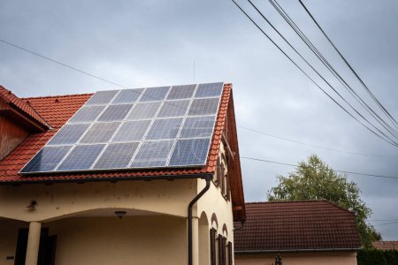 Solaranlage auf dem Dach eines Wohnhauses, ein altes und renoviertes Haus in Ungarn mit Photovoltaik-Modulen, die als Sonnenkollektoren bezeichnet werden und zur Stromerzeugung mit Sonnenenergie verwendet werden