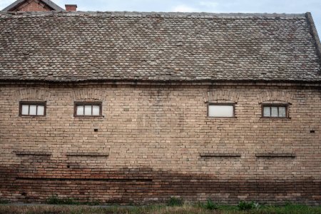 Facade of an old house building from abandoned farmhouse in alibunar, in Serbia with Condemned, boarded and bricked up windows. The Balkans, in Europe, is hit by a rural exodus & emigration deserting.