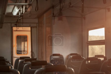 Desenfoque selectivo en un interior de una UEM con asientos vacíos en un antiguo tren suburbano, de estilo europeo, en un viaje en un entorno urbano al atardecer en serbia.