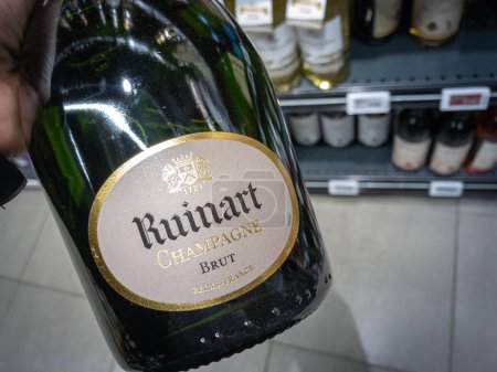 Téléchargez les photos : PARIS, FRANCE - 1er FÉVRIER 2024 : Logo champagne Ruinart sur des bouteilles exposées dans une boutique. Faisant partie de LVMH, c'est une marque française de vin de champagne, une icône de l'alcool de luxe. - en image libre de droit