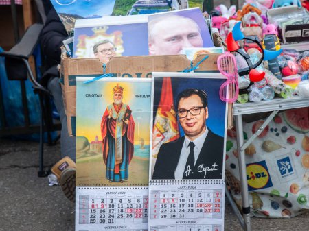 Photo for RUMENKA, SERBIA - JANUARY 30, 2023: calendars portraying Aleksandar Vucic, president of Serbia, next to an orthodox icon and a portrait of Vladimir putin president of russia in background in Serbia. - Royalty Free Image