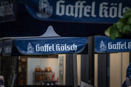 Foto de COLOGNE, ALEMANIA - 12 DE NOVIEMBRE DE 2022: Desenfoque selectivo en un logotipo de Gaffel Kolsch Beer en un minorista local. Gaffel es una cerveza Kolsch, una cerveza tradicional de la región de Colonia. - Imagen libre de derechos