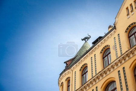Foto de Desenfoque selectivo en la escultura de gato de la azotea de Kaku Maja, o casa del gato de Riga, con un cielo azul. Diseñado por Friedrich Scheffel en 1909, es un hito del art nouveau en Riga, Latvia. - Imagen libre de derechos