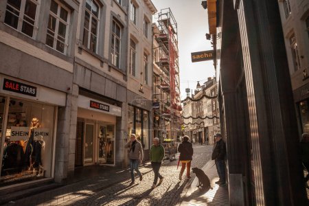 Photo for MAASTRICHT, NETHERLANDS - NOVEMBER 10, 2022: Selective blur on dutch people walking in munstraat street in Maastricht city center, a pedestrian street surrounded by shops and stores. - Royalty Free Image