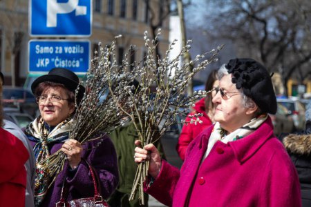 Téléchargez les photos : SOMBOR, SERBIE - 20 MARS 2016 : Flou sélectif sur une vieille femme tenant une marque pour le dimanche des Rameaux catholiques à Sombor, Serbie, lors d'une célébration catholque en Serbie. - en image libre de droit