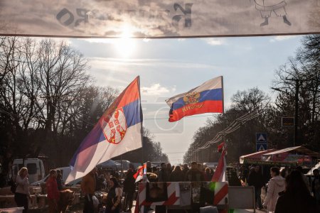 Photo for KACAREVO, SERBIA - FEBRUARY 22, 2023: Selective blur on the flags of Serbia and russia flying together in a market of Kacarevo, Serbia. Russia has a strong influence in the balkans and especially in serbian areas. - Royalty Free Image