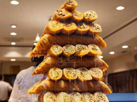 Selektive Unschärfen auf einem Haufen Baklava, gestapelt, vor Zucker triefend, der in einer Boutique in Istanbul, Türkei, zum Verkauf steht. Baklava sind ein süßes Café-Gebäck aus dem Nahen Osten, typisch für die türkische Küche.