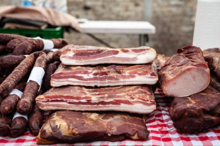 Photo for Selective blur on blocks of slanina, a serbian bacon, made of dried cured pork, smoked, on the stand of a countryside market of Serbia. It's a traditional meat product from Balkans. - Royalty Free Image