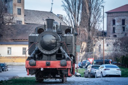 Foto de Desenfoque selectivo en una locomotora de vapor negro vintage que se encuentra en un patio de una estación de tren abandonada en Pancevo, Serbia. Es una locomotora de tren de carbón muerta, ahora decomisionada.. - Imagen libre de derechos