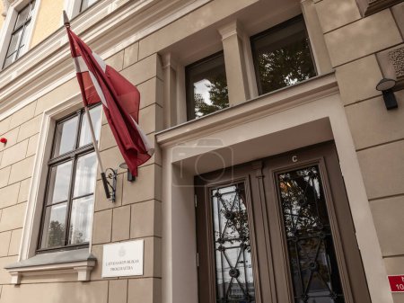 RIGA, LETTLAND - 21. AUGUST 2023: Lettland republikas prokuratura office, das Büro des lettischen Generalstaatsanwalts, in Riga, eines der Staatsoberhäupter der Justiz, mit der lettischen Flagge davor.