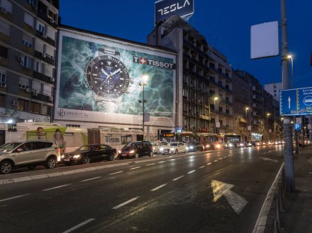 Photo for BELGRADE, SERBIA - SEPTEMBER 2, 2020: Traffic Jam of cars & other vehicles on Brankova ulica street at night at peak hour, with heavy pollution, by a tissot poster. Belgrade is capital city of Serbia. - Royalty Free Image