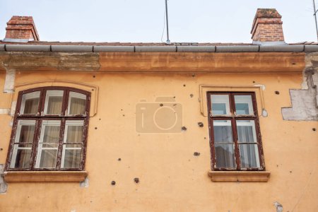 Beschädigtes Haus im Zentrum von Osijek, Kroatien mit Einschusslöchern. Die Stadt wurde zum Zentrum des Konflikts zwischen Serbien und Kroatien zwischen 1991 und 1995, wobei lokale Bauwerke durch Beschuss und Kugelfeuer beschädigt wurden..