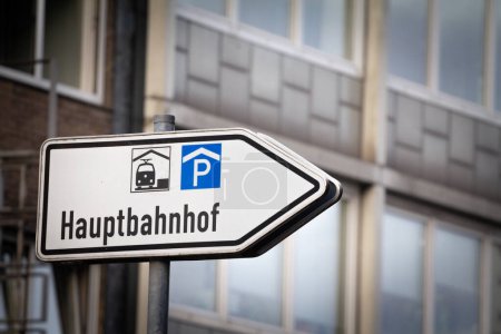 Selective blur on a roadsign indicating the direction to Hauptbahnhof, meaning Main train station in German, in aachen hbf, a multimodal transportation hub for railway and other transports.