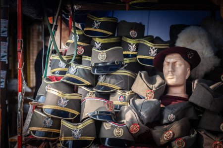 Foto de BELGRADA, SERBIA - 12 DE FEBRERO DE 2024: Sombreros tradicionales serbios: sajkaca y oficirska kapa en venta en un mercado de belgrado. Estos son típicos gorros de lana verde, inspirados en los militares. - Imagen libre de derechos